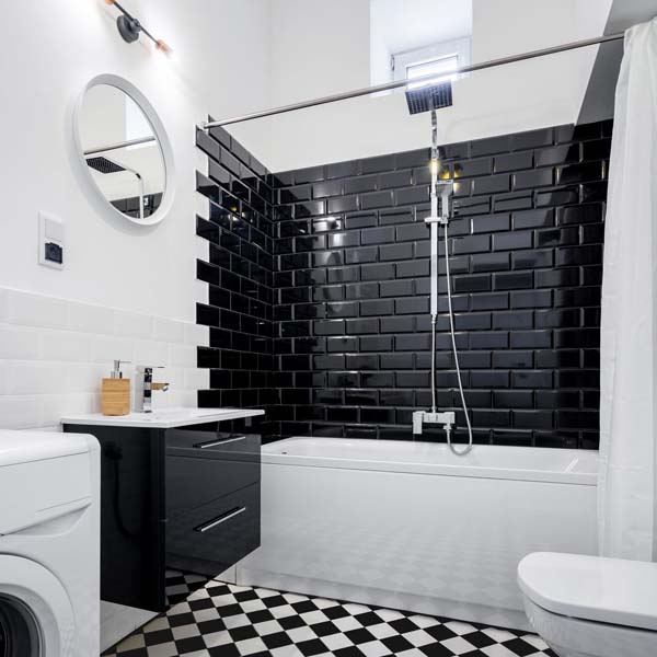 черная плитка на одной стене в ванной